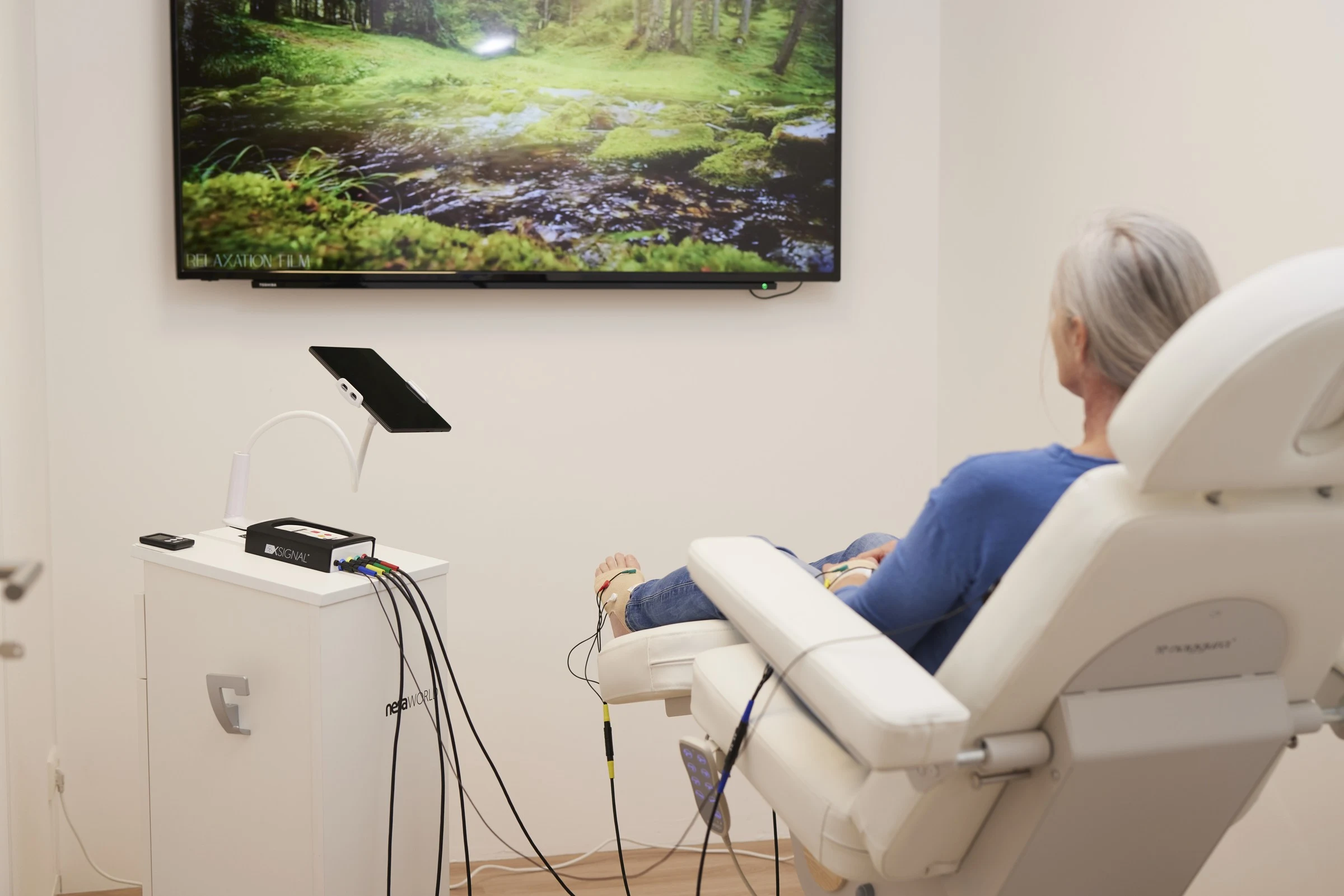 NESA-sessie in een behandelstoel met elektroden aan handen en voeten